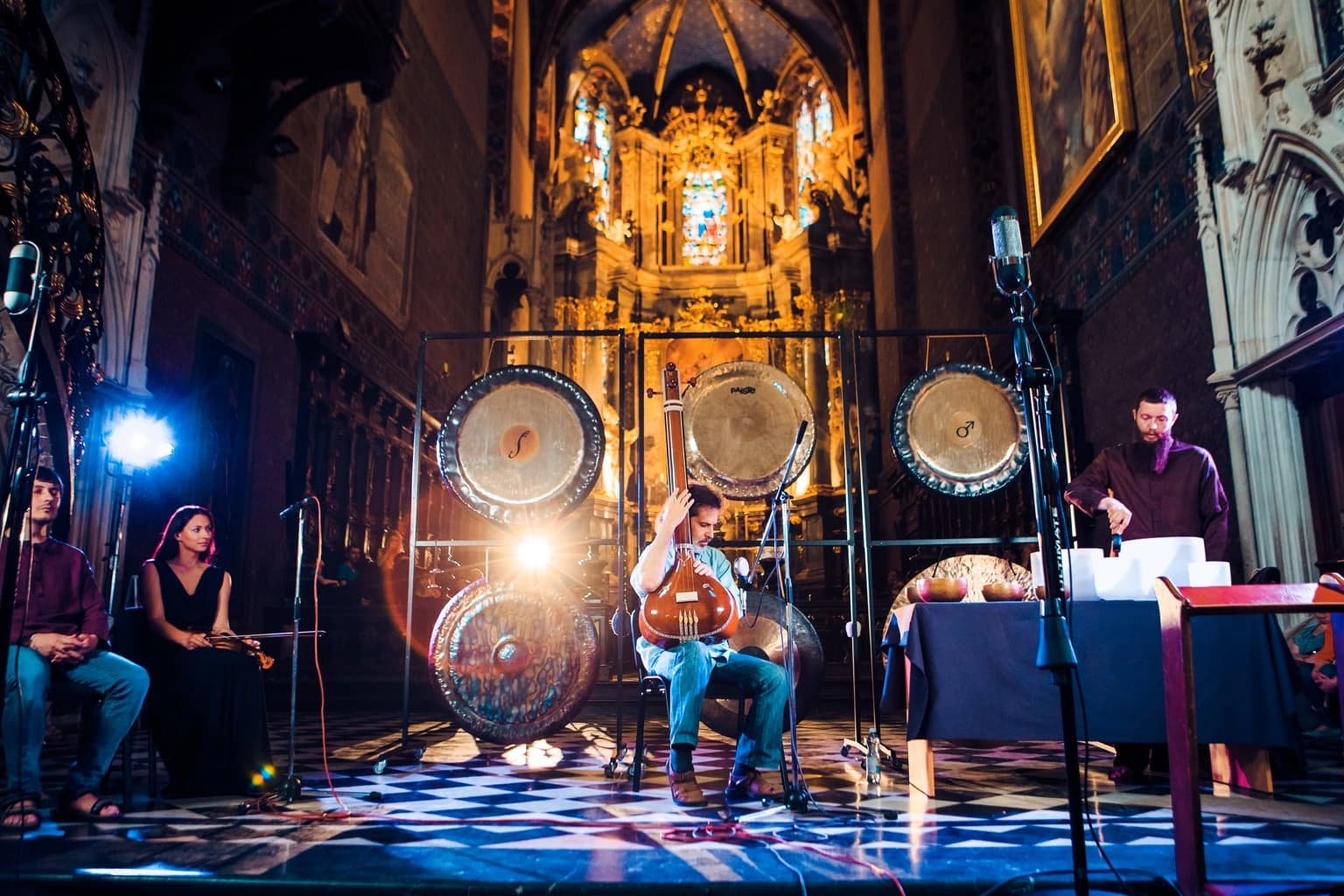 Musicians performing among gongs inside the cathedral